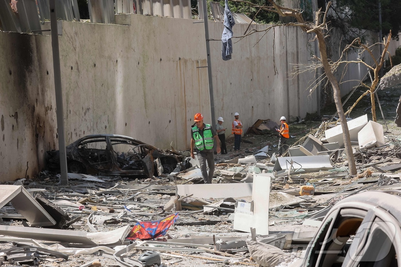 19일(현지시간) 이란의 공격으로 인해 피해를 입은 이스라엘 텔아비브 근처 라마트간의 한 거리에서 구조대가 현장을 살펴보고 있다. 2025.06.19 ⓒ AFP=뉴스1 ⓒ News1 김지완 기자