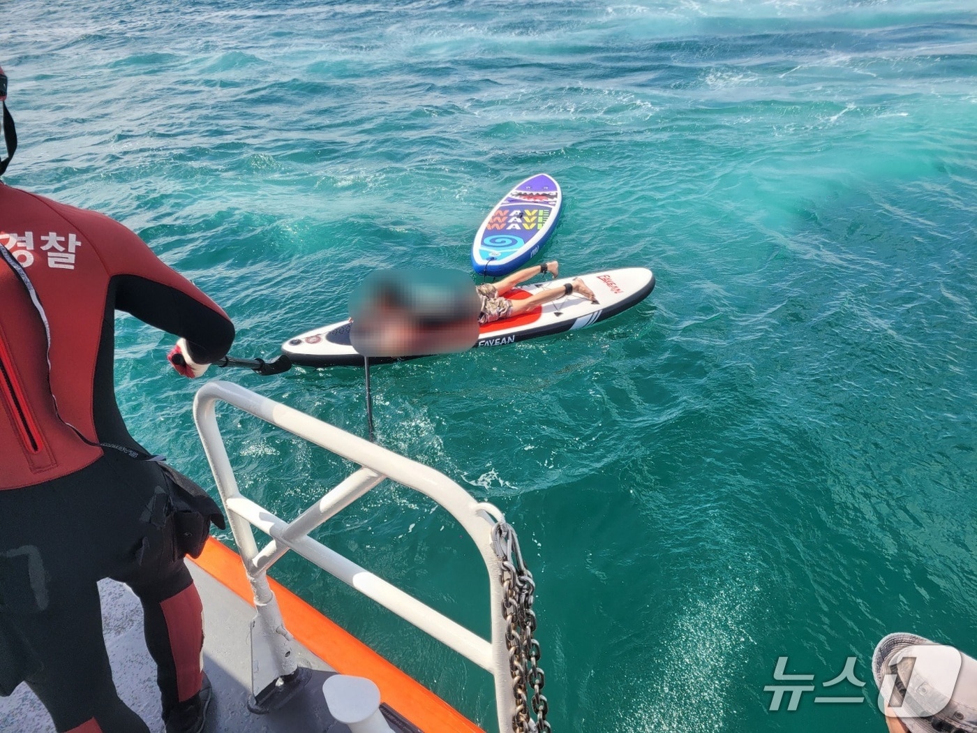 제주해경이 패들보드로 관광객을 구하려다 표류한 레저업체 직원을 구조하고 있다./뉴스1 