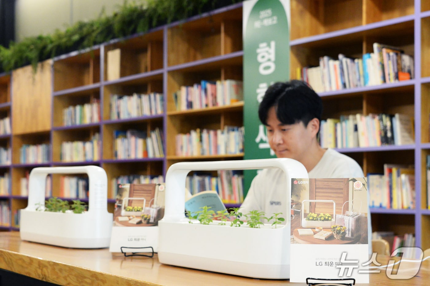 LG 틔운 미니를 활용해 조성된 내부 서가와 열람실 공간에서 독서하며 다양한 식물을 감상하는 모습(LG전자 제공). ⓒ 뉴스1