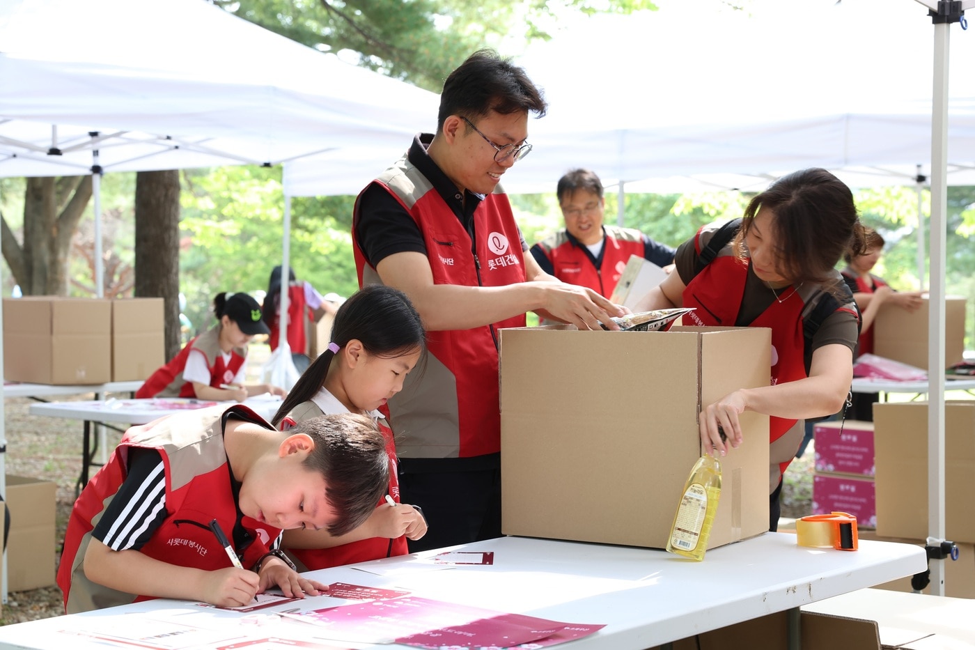  롯데건설 '샤롯데 봉사단'이 국가유공자 보훈가정을 위한 응원카드를 작성하고 기부 물품을 포장하고 있다. /롯데건설 제공