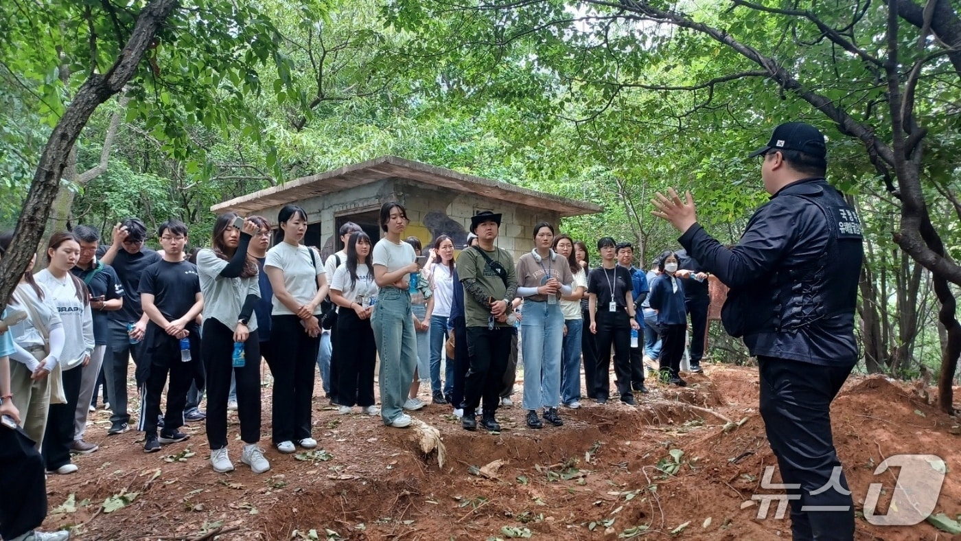 오승래 국방부 유해발굴단 발굴7팀장이 유해발굴 현장을 찾은 국방부 직원들에게 유해발굴 현장을 소개하고, 해당 지역의 지형 및 전사, 발굴유품 등을 설명하고 있다. 2025.06.24. (국방부 제공)