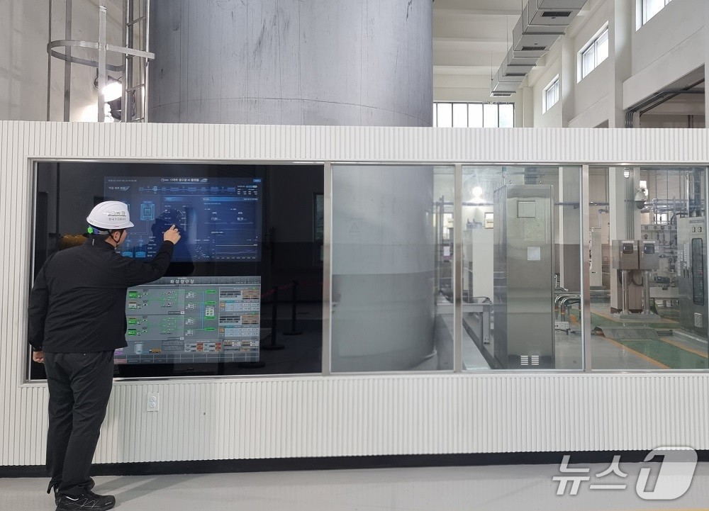 한국수자원공사 관계자가 경기도 화성에 있는 AI 정수장에서 약품주입동에 구현된 ‘스마트 미러’(터치형 화면)를 보며 정수처리에 필요한 약품주입 자율공정 현황 등을 살펴보고 있다. (한국수자원공사 제공.재판매 및 DB금지)/뉴스1