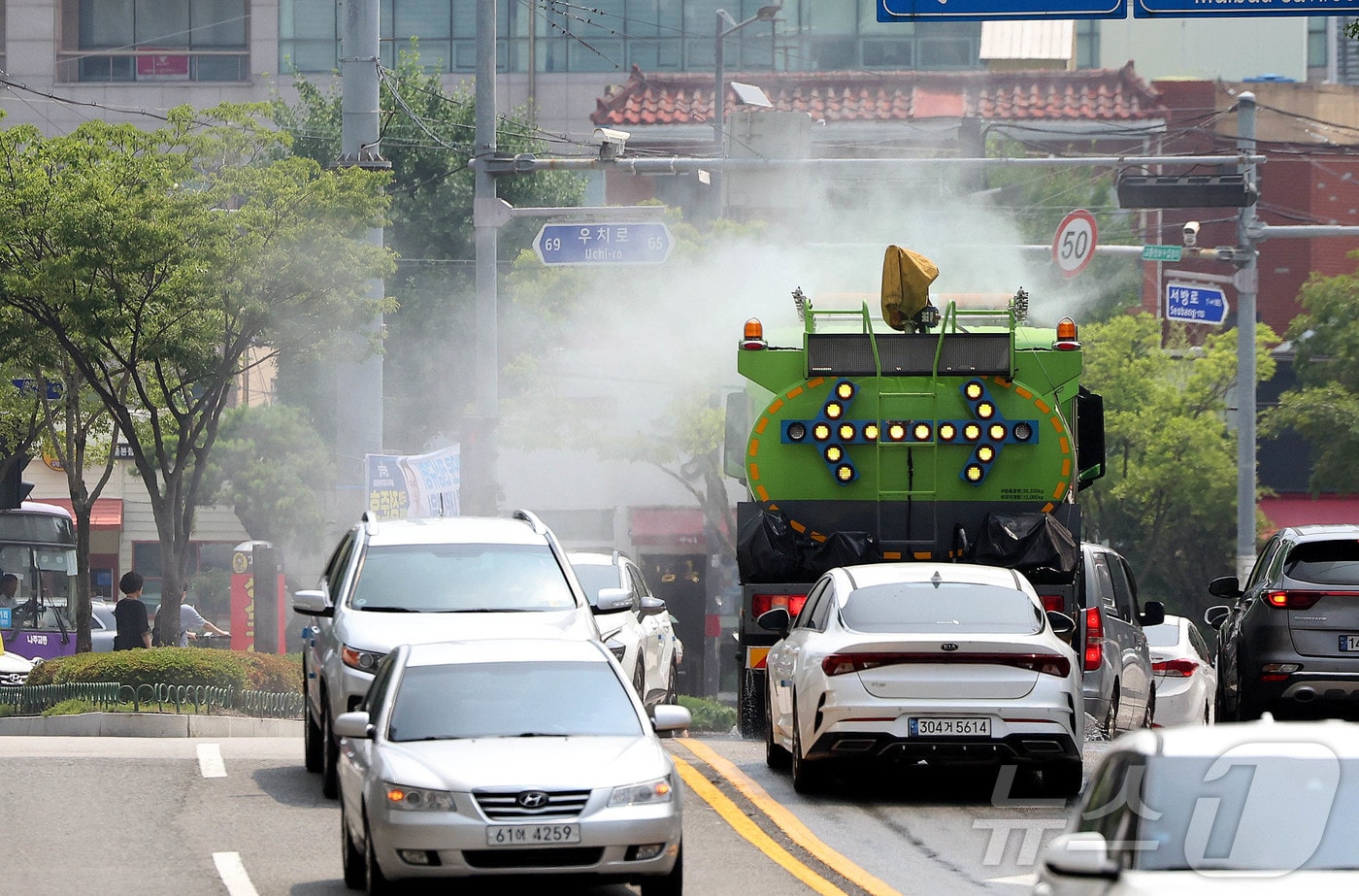 낮 기온이 30도를 웃돌아 무더운 날씨를 보인 26일 광주 북구청 기후환경과 직원들이 살수차를 이용해 도로의 지열을 식히고 있다. (광주 북구 제공. 재판매 및 DB 금지)