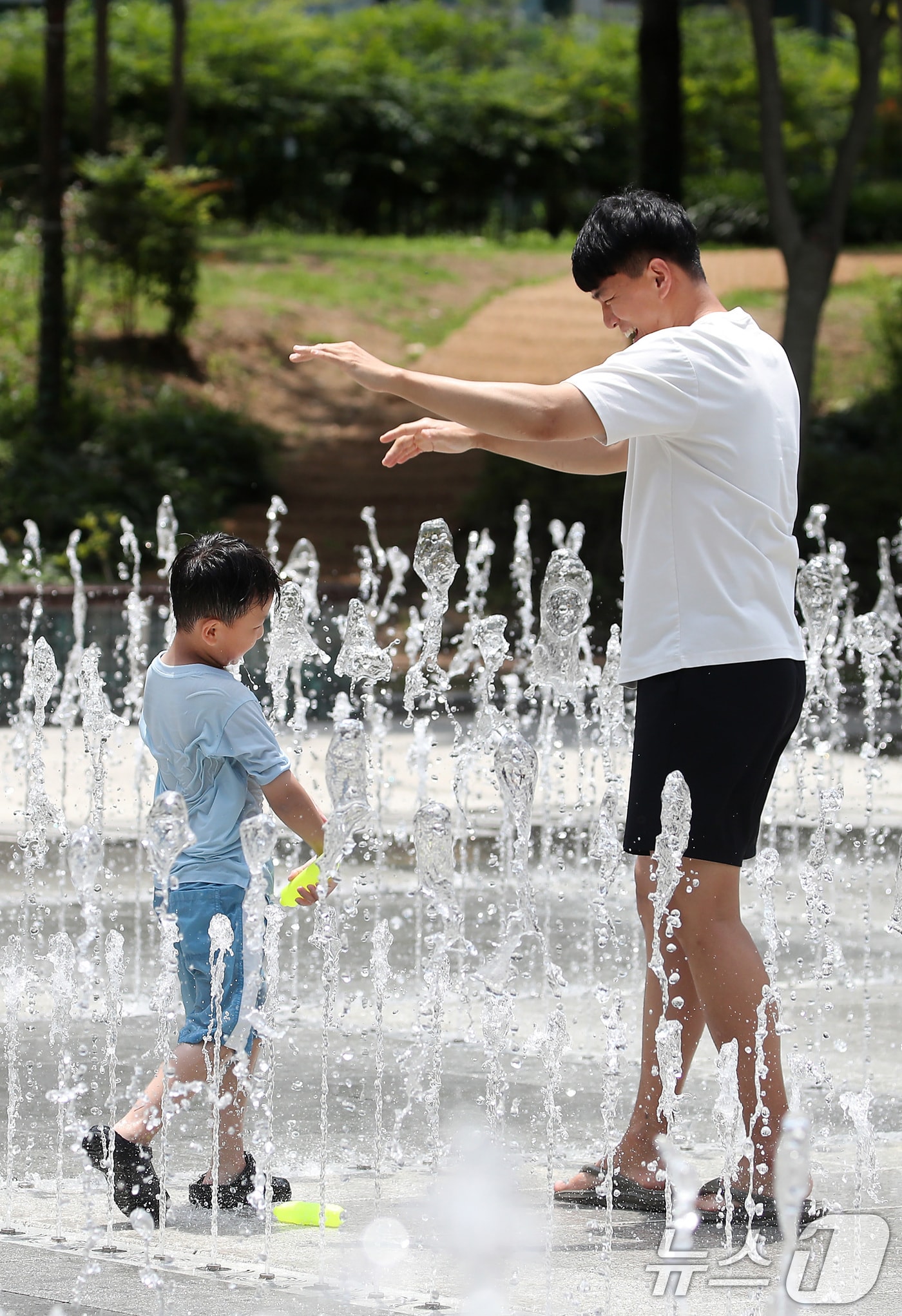 6월 마지막 휴일 대구와 경북 곳곳에 폭염특보가 발효되는 등 불볕더위를 나타내고 있다. 사진은 지난 27일 오후 대구 서구 평리공원 바닥분수에서 아이와 아빠가 물장난을 치며 더위를 식히는 모습 2025.6.27/뉴스1 ⓒ News1 공정식 기자