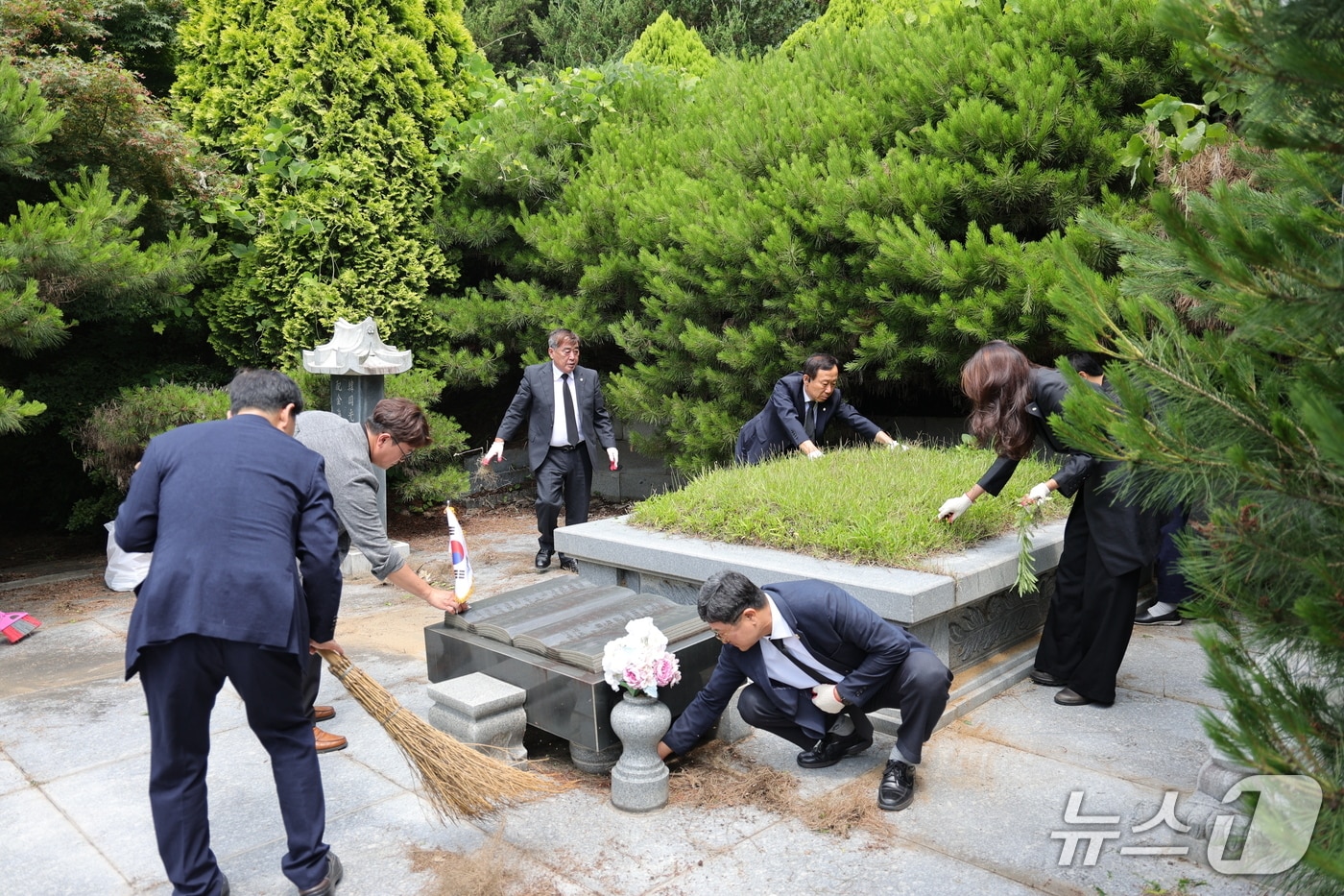 서천군의회 의원들이 독립유공자 김갑수 지사의 묘소에 참배한 뒤 묘역을 정돈하고 있다.(서천군의회 제공. 재판매 및 DB금지)/뉴스1