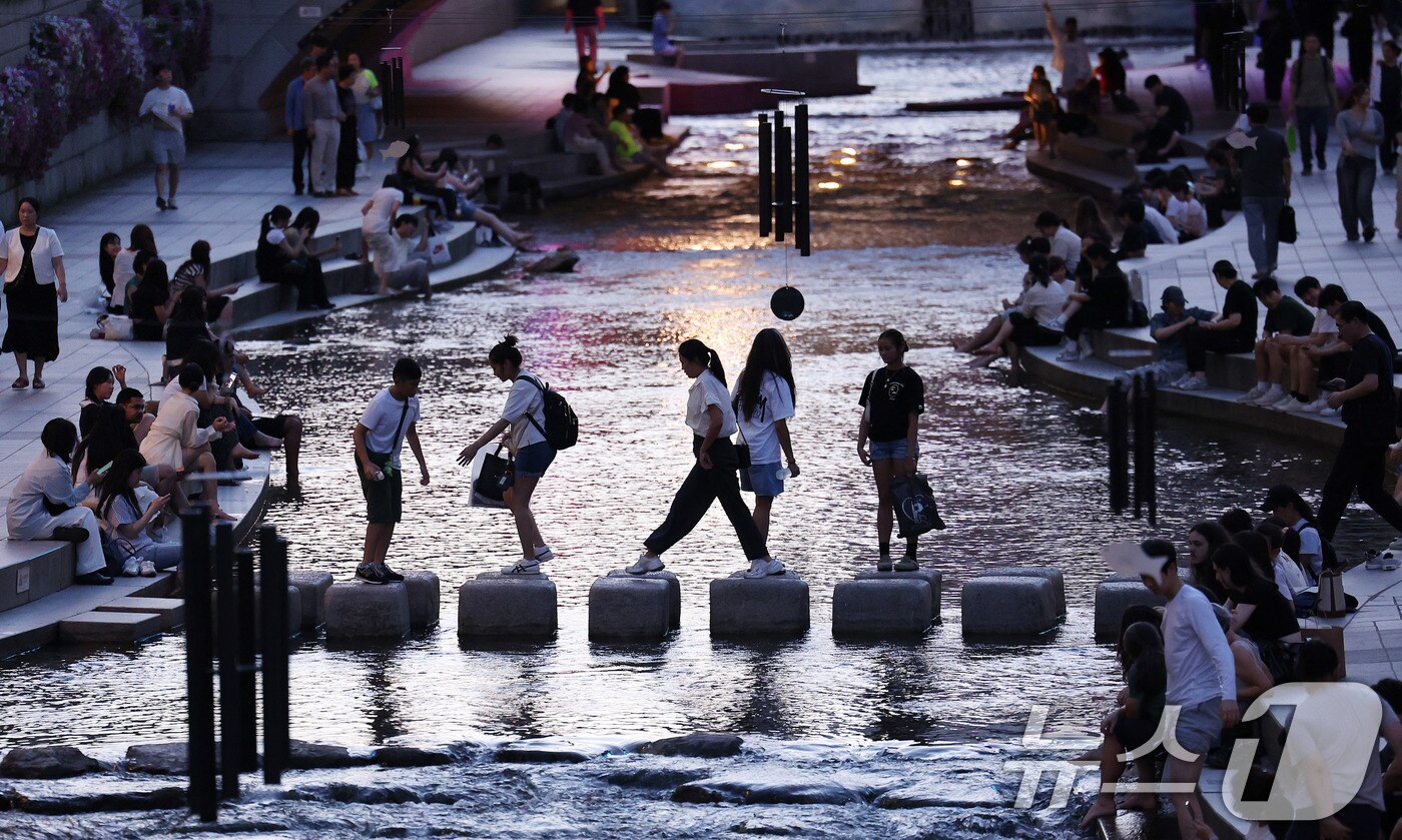 서울에 올해 처음으로 열대야가 기록된 30일 서울 청계천에서 시민들과 외국인 관광객들이 더위를 식히고 있다. 열대야는 밤 사이(전날 오후 6시 1분부터 다음날 오전 9시까지) 기온이 25도 이상으로 유지되는 현상이다. 2025.6.30/뉴스1 ⓒ News1 박지혜 기자