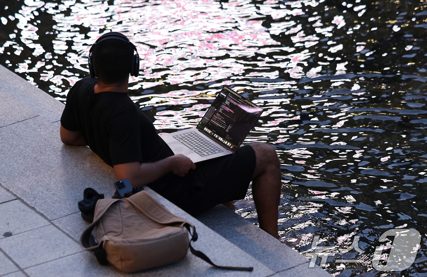 서울에 올해 처음으로 열대야가 기록된 30일 서울 청계천에서 한 외국인이 물에 발을 담근 채 음악감상을 하고 있다. 열대야는 밤 사이(전날 오후 6시 1분부터 다음날 오전 9시까지) 기온이 25도 이상으로 유지되는 현상이다. 2025.6.30/뉴스1 ⓒ News1 박지혜 기자