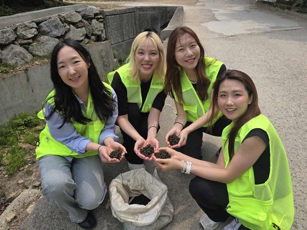 밝은 표정으로 다슬기를 들고 포즈를 취한 참가자들. 생태 복원의 의미를 되새기며 환하게 웃고 있다. 사진=푸른환경실천협의회 제공