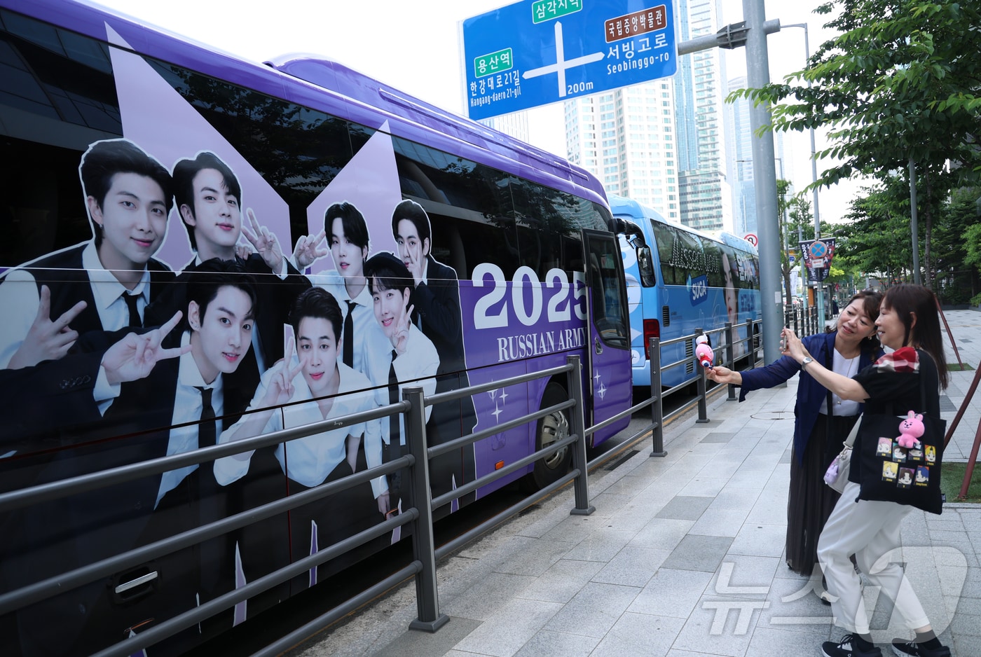 9일 오전 서울 용산구 하이브 사옥 앞에서 방탄소년단(BTS) 글로벌 팬들(아미)이 멤버들의 제대를 기대하며 기념 촬영을 하고 있다. 2023년 12월 입대한 그룹 방탄소년단(BTS)의 RM, 뷔, 지민, 정국이 이번 주 육군 현역 복무를 마치고 만기 전역한다. 2025.6.9/뉴스1 ⓒ News1 권현진 기자