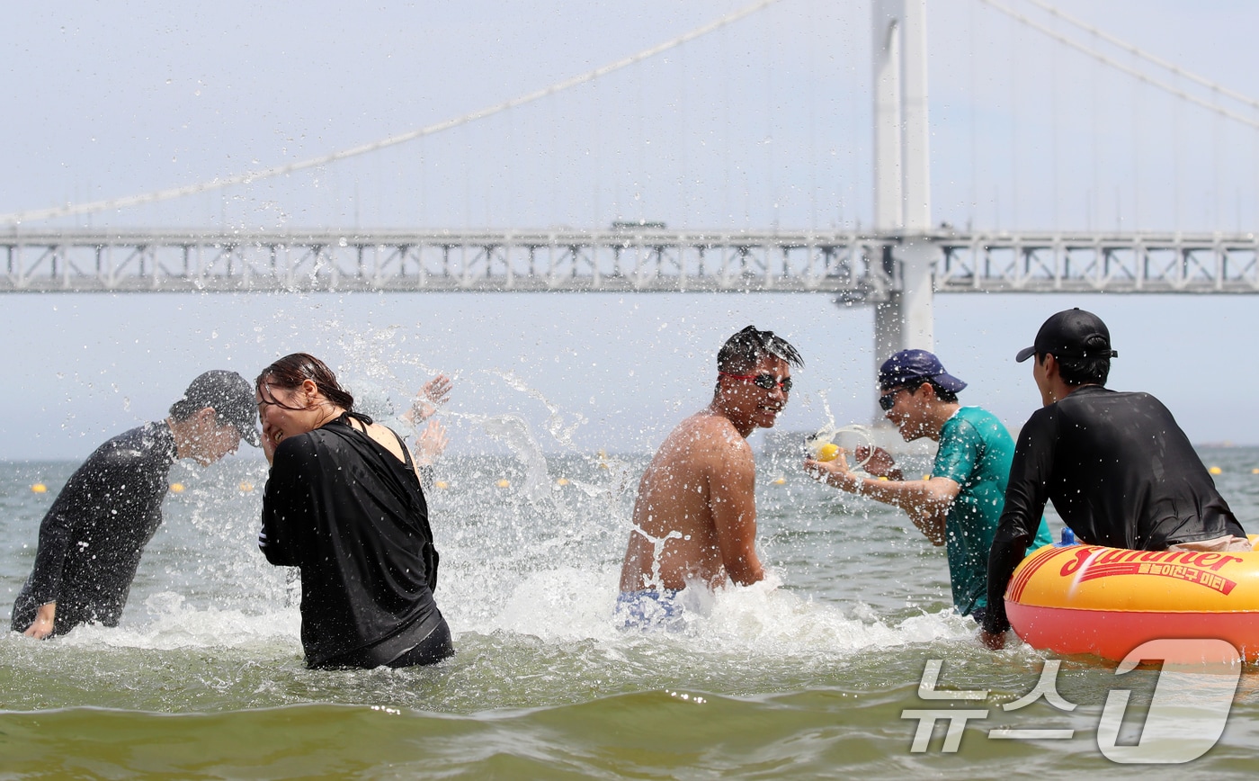 무더위가 기승을 부린 1일 개장한 부산 수영구 광안리해수욕장을 찾은 관광객들이 물놀이를 즐기며 더위를 식히고 있다.2025.7.1/뉴스1 ⓒ News1 윤일지 기자