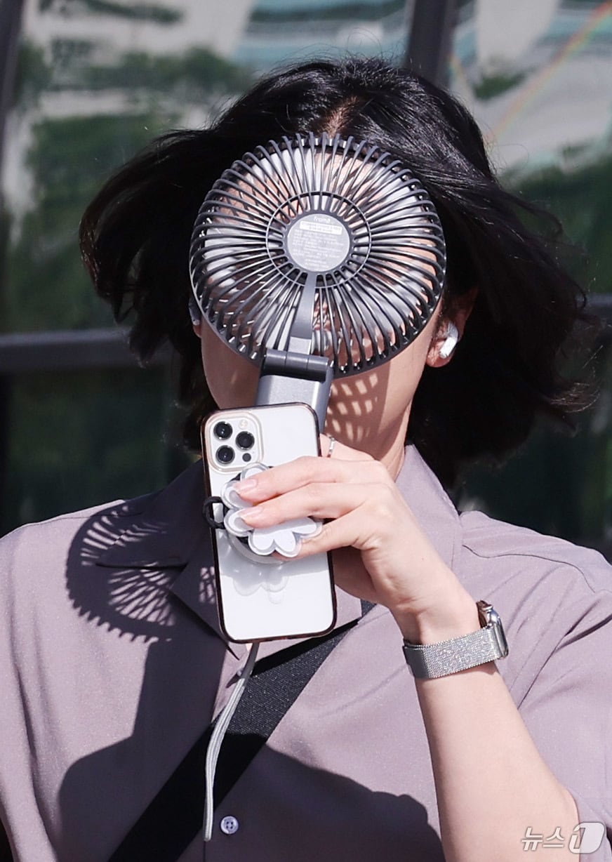 한 시민이 손선풍기를 얼굴에 대며 출근하고 있다. (사진은 기사 내용과 무관함) / 뉴스1 ⓒ News1