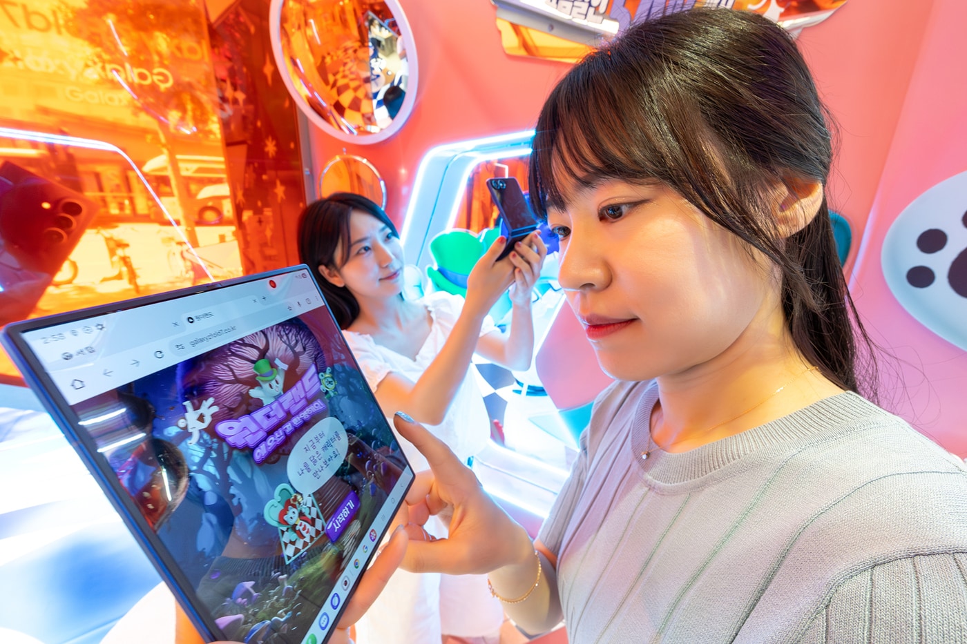 모델들이 KT 홍대 애드샵 플러스에 마련된 ‘갤럭시 Z 폴더블7 AI 체험존’에서 AI 기반 콘텐츠를 체험하고 있다. (KT 제공)