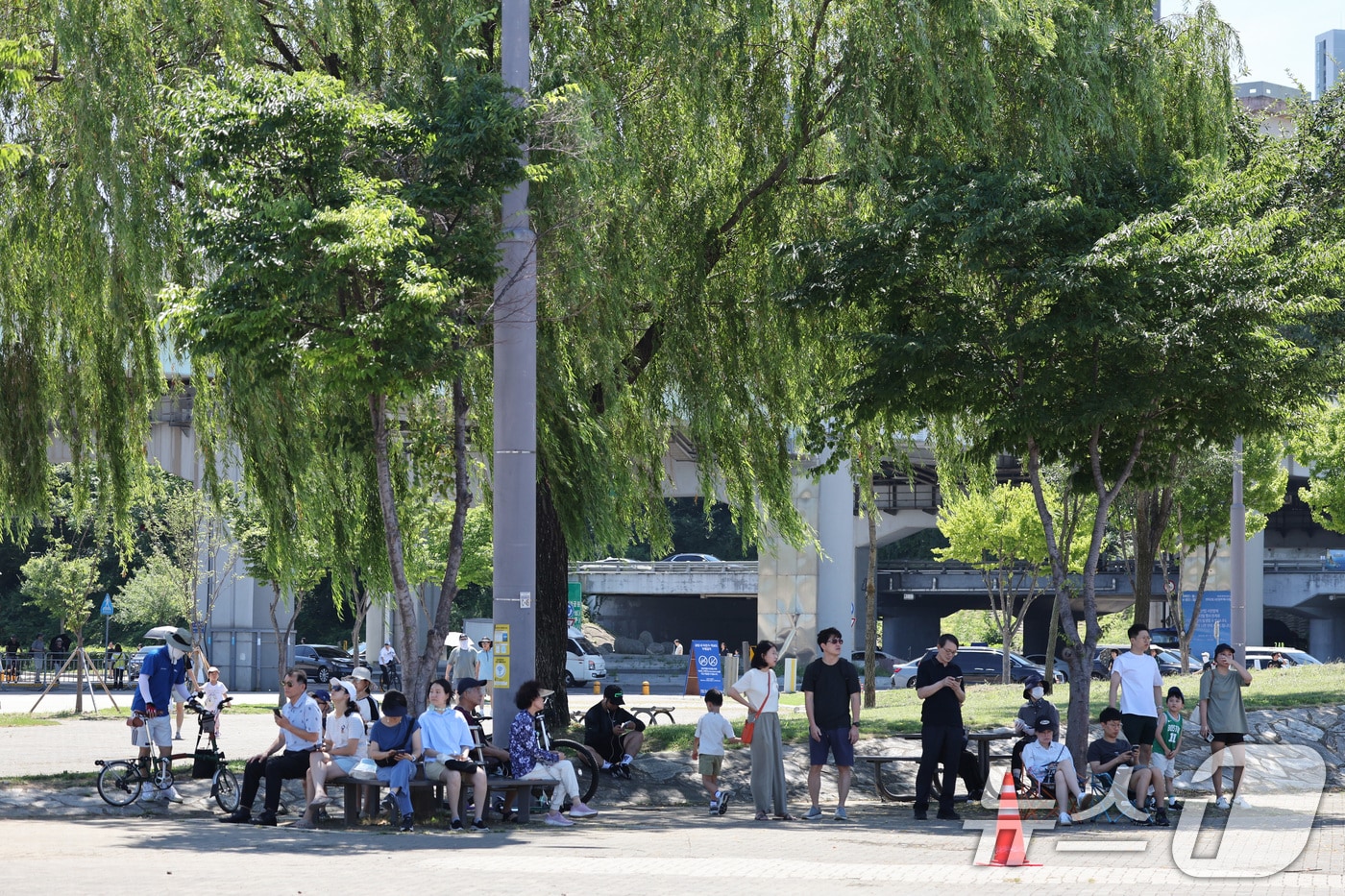 12일 오전 서울 반포한강공원에서 시민들이 공군 특수비행팀 블랙이글스의 에어쇼를 보기 위해 그늘에서 기다리고 있다. 2025.7.12/뉴스1 ⓒ News1 신웅수 기자