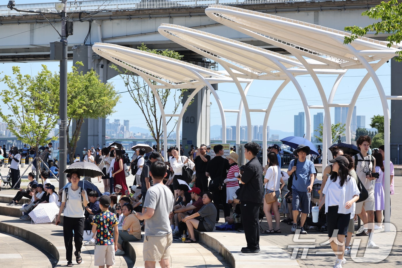 12일 오전 서울 반포한강공원에서 시민들이 공군 특수비행팀 블랙이글스의 에어쇼를 보기 위해 그늘에서 기다리고 있다. 2025.7.12/뉴스1 ⓒ News1 신웅수 기자