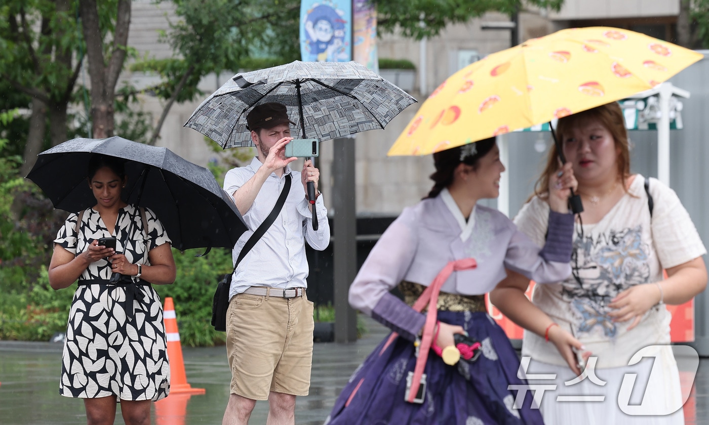 서울 종로구 광화문광장에서 외국인 관광객들이 우산을 쓴 채 발걸음을 옮기고 있다. 2025.7.14/뉴스1 ⓒ News1 김성진 기자