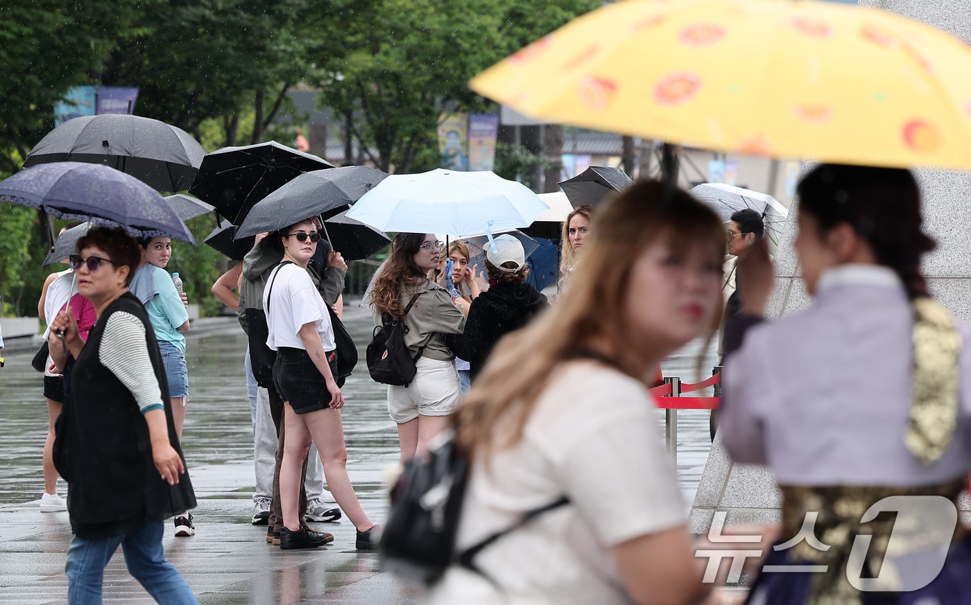 전국 대부분 지역에 비가 내린 14일 서울 종로구 광화문광장에서 외국인 관광객들이 우산을 쓴 채 발걸음을 옮기고 있다. 2025.7.14/뉴스1 ⓒ News1 김성진 기자