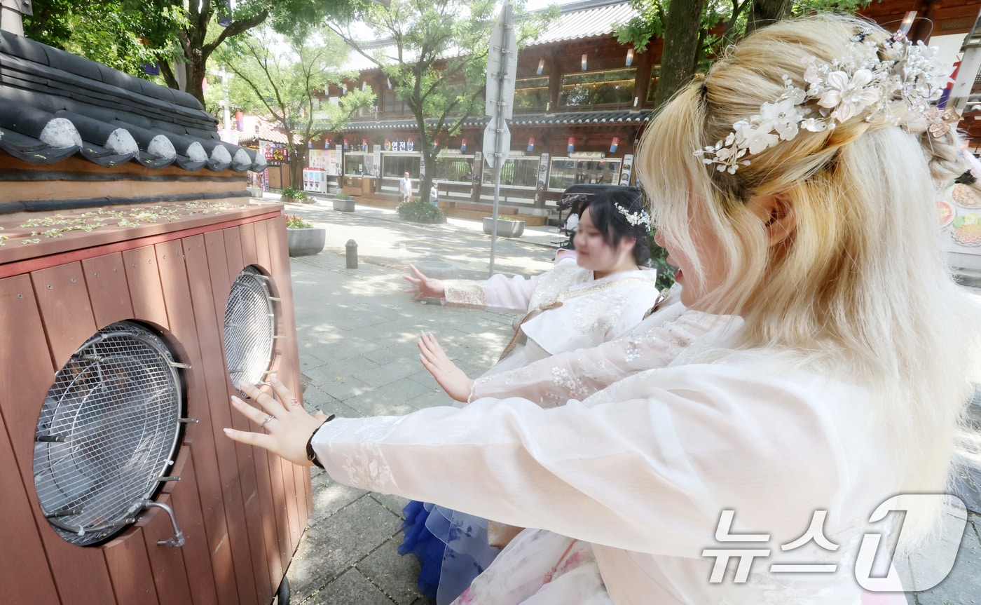 14일 전북 전주시 한옥마을 태조로에서 관광객들이 쿨링포그 앞에서 더위를 식히고 있다. 2025.7.14/뉴스1 ⓒ News1 유경석 기자