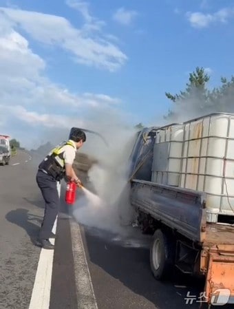 지난 14일 오후 서귀포시 한 도로 위 1톤 트럭에서 불이 나 제주자치경찰단이 소화기로 진압하고 있다.(제주자치경찰단 제공. 재판매 및 DB 금지)