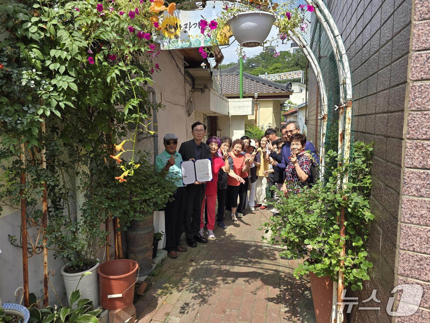대구 서구 소재 달성토성마을 골목정원이 대구시 1호 공동체 정원으로 지정돼 주민들이 단체 사진을 촬영하고 있다.(대구 서구 제공.재판매 및 DB 금지)