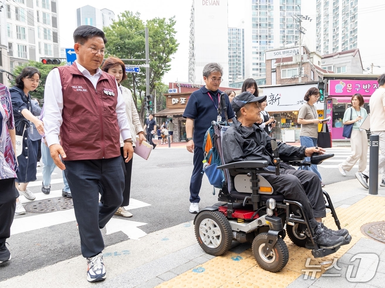 박강수 마포구청장이 휠체어를 탄 주민과 함께 새로 조성된 무장애길을 걷고 있다.(마포구 제공)