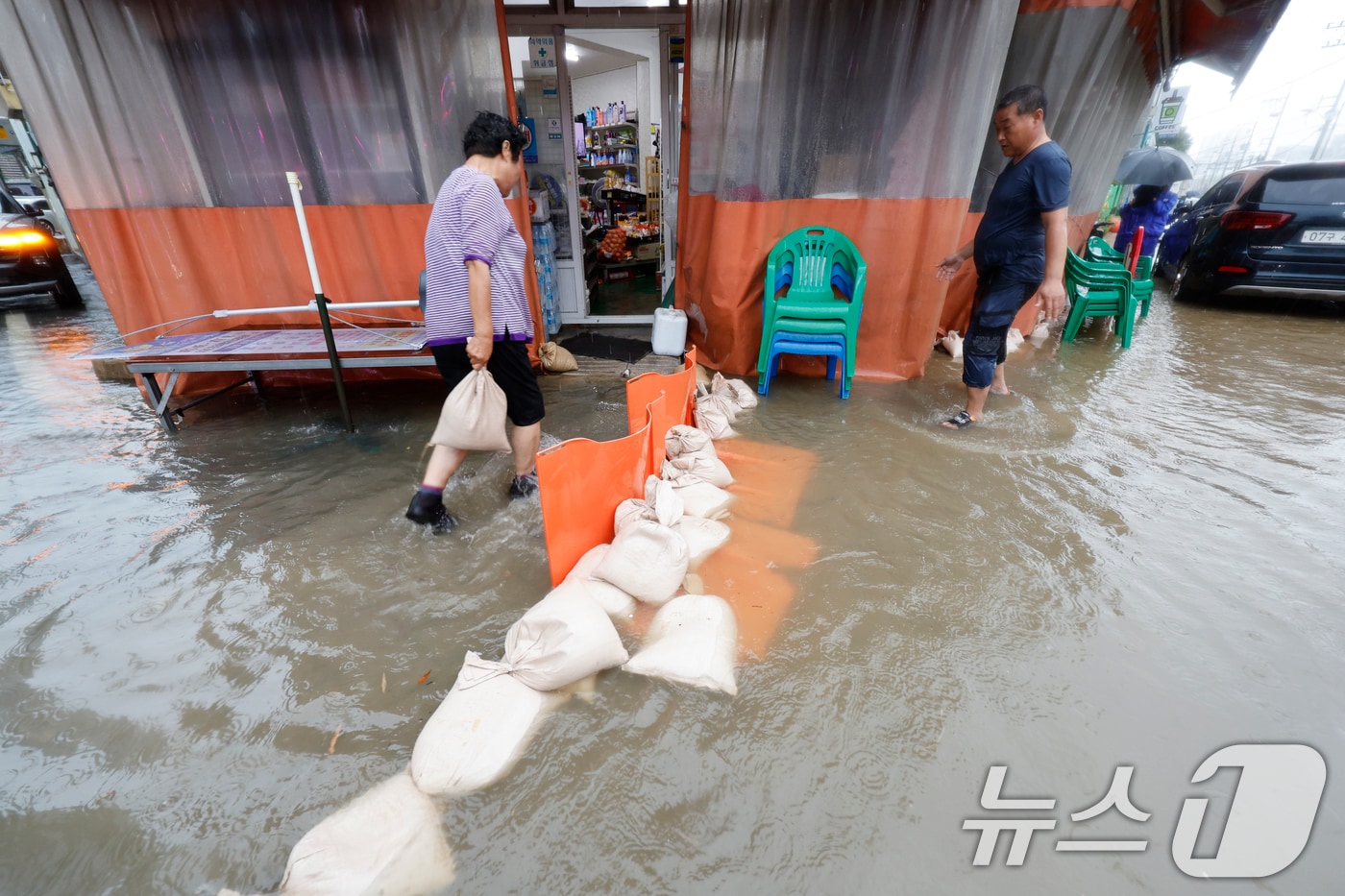 호우경보가 발효된 17일 광주 남구 백운동 일대의 상가가 침수돼 주인이 가게앞 모래주머니를 쌓고있다. 2025.7.17/뉴스1 ⓒ News1 김태성 기자