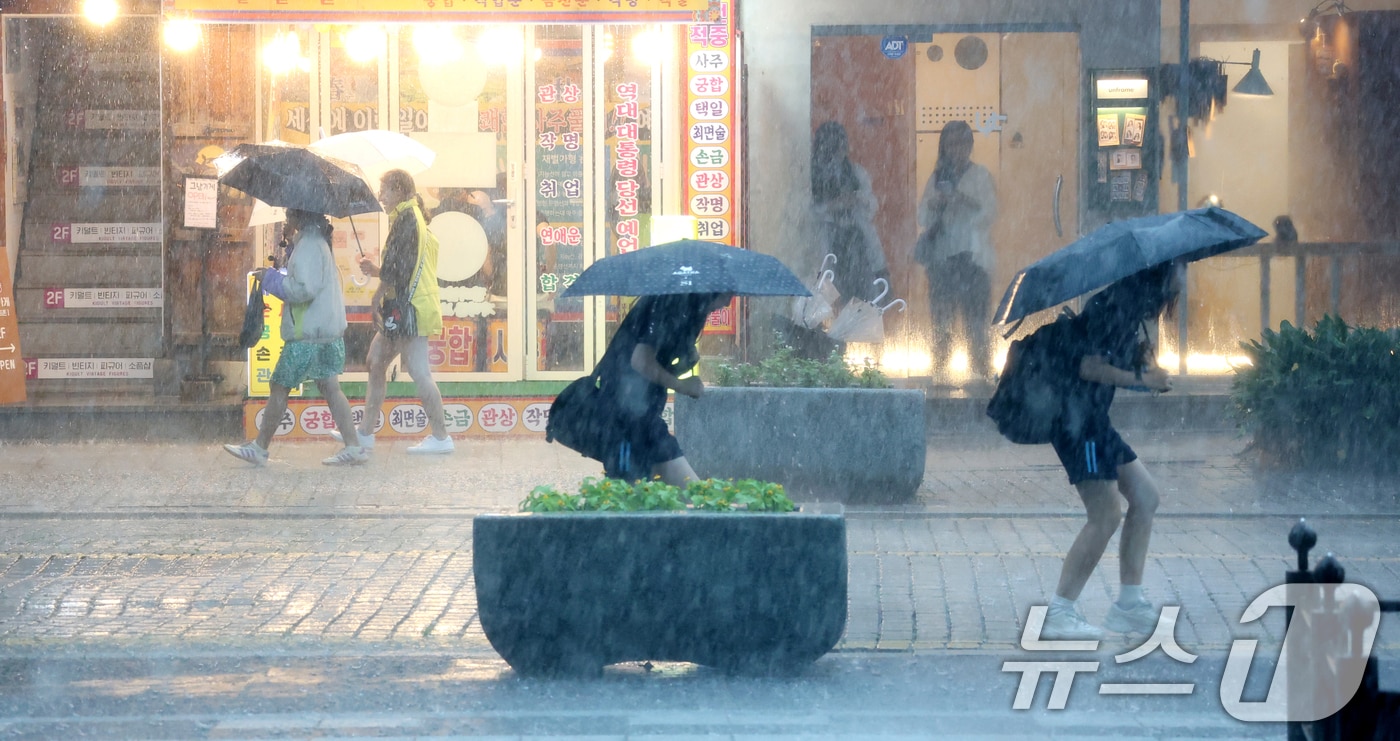전북 전 지역에 호우특보 발효된 17일 전북 전주시 한옥마을 경기전에서 우산을 쓴 관광객들이 발걸음을 재촉하고 있다. 2025.7.17/뉴스1 ⓒ News1 유경석 기자