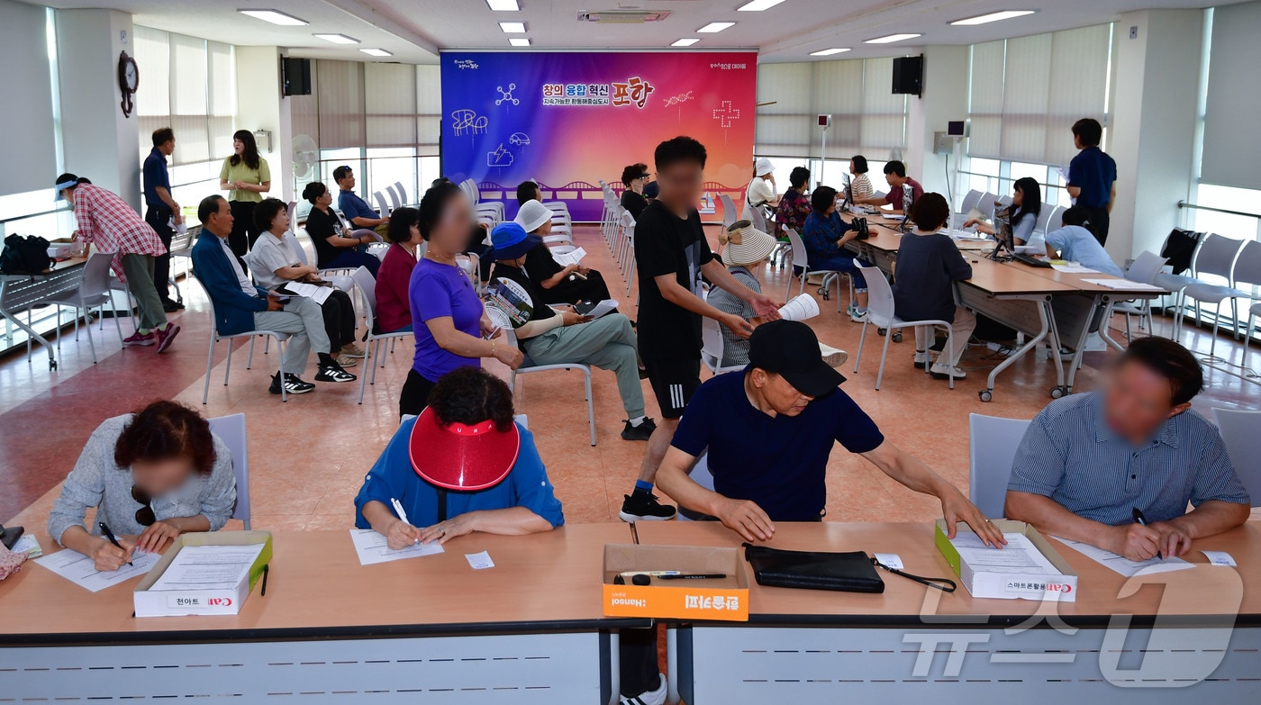 민생회복 소비쿠폰 신청 첫 날인 21일 오전 경북 포항시 남구 대이동 행정복지센터 2층에서 시민들이 신청서를 작성하고 있다. 2025.7.21/뉴스1 ⓒ News1 최창호 기자