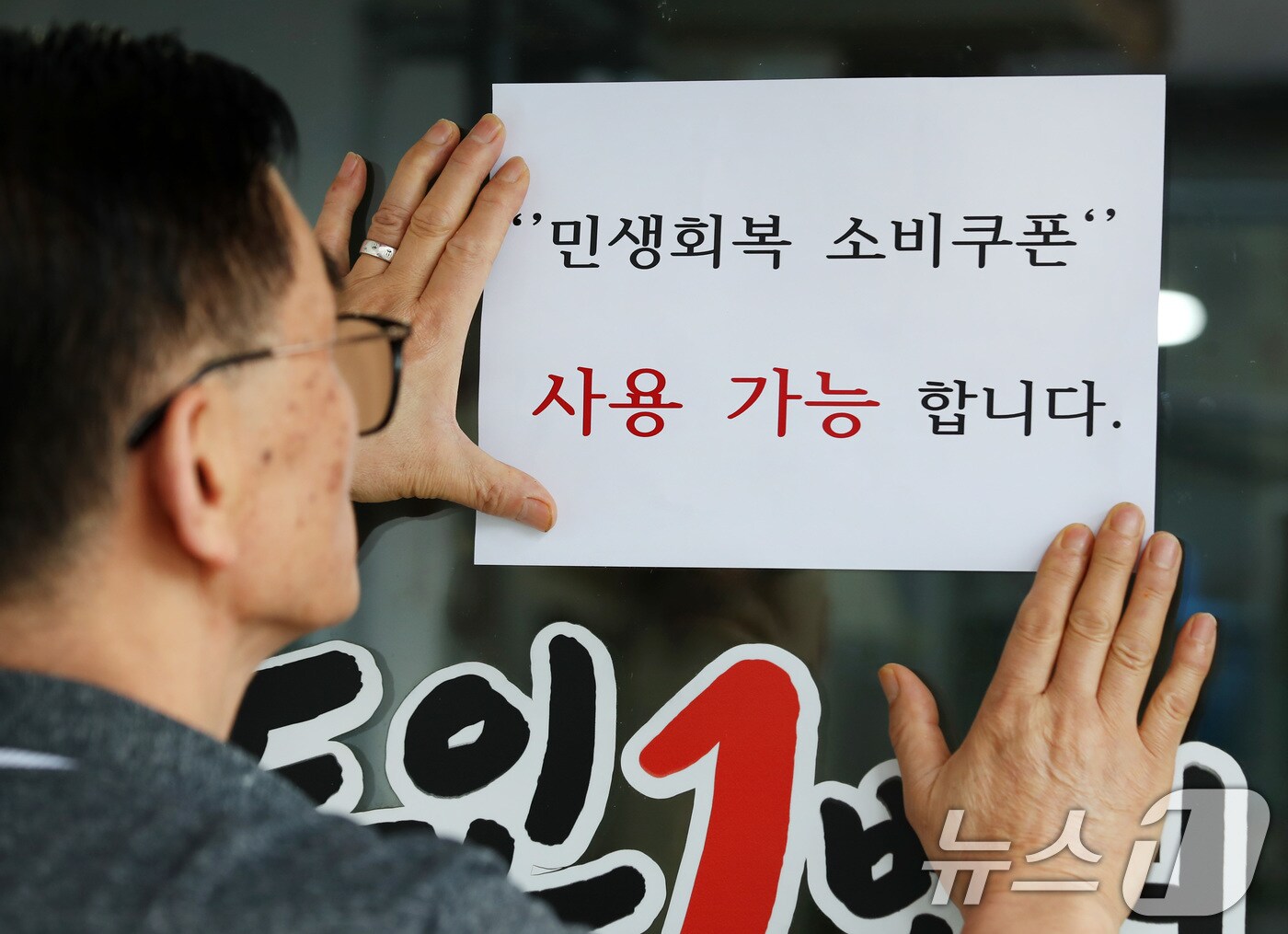22일 오후 대구 중구의 한 음식점 주인이 출입문에 민생회복 소비쿠폰 사용 가능 안내문을 붙이고 있다. 2025.7.22/뉴스1 ⓒ News1 공정식 기자