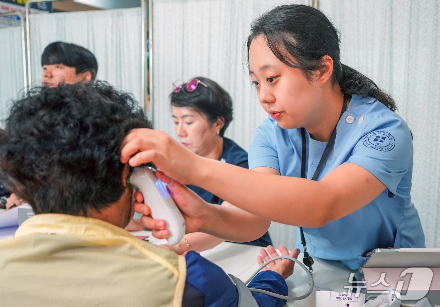 대구보건대 한달빛 봉사단원인 간호학과 학생이 안동시 길안면 백자리 마을회관에서 노인들의 혈압과 체온을 재고 있다.(대구보건대 제공. 재판매 및 DB 금지)