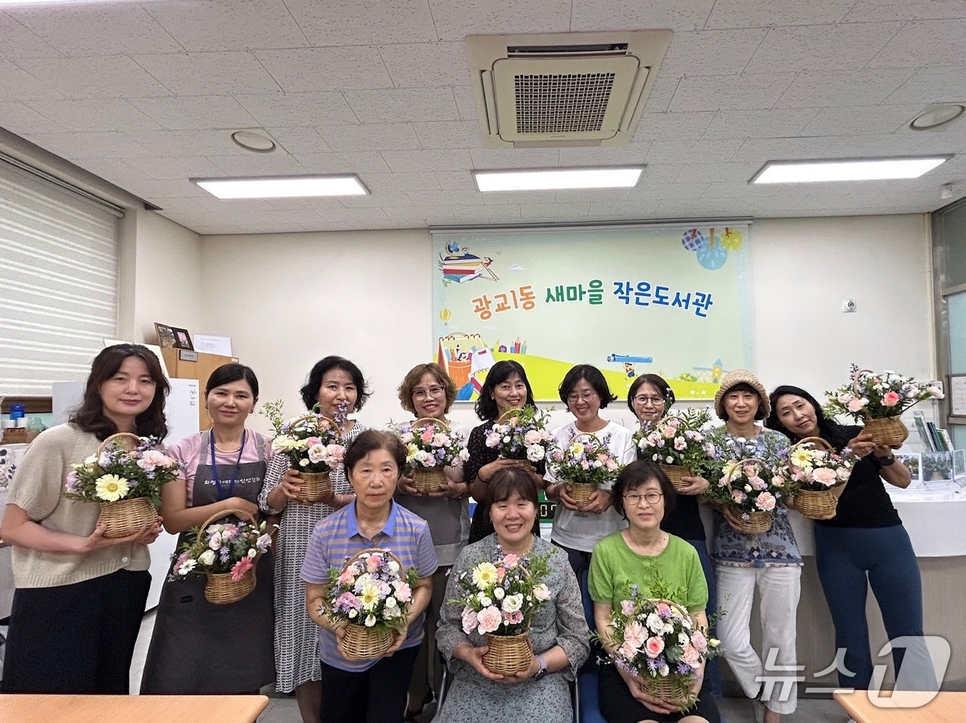 경기 수원시 영통구 광교1동 새마을문고회가 22일 회원과 주민을 대상으로 '힐링 꽃꽂이 교실'을 진행한 후 기념촬영을 하고 있다. (광교1동 제공. 재판매 및 DB 금지) 2025.7.22/뉴스1