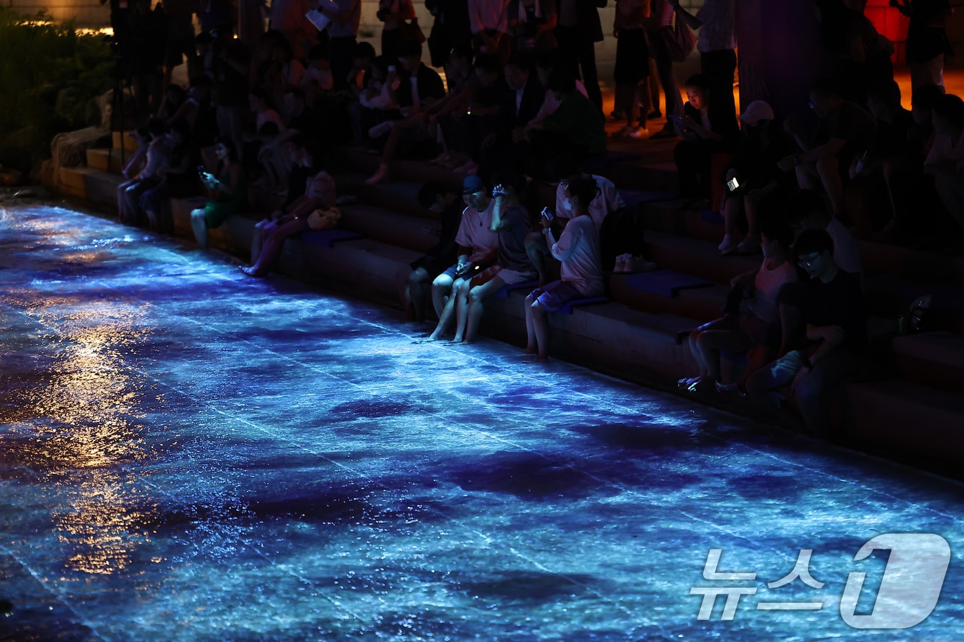 무더위가 이어진 23일 서울 중구 청계천을 찾은 시민들이 수면 미디어아트를 보며 더위를 식히고 있다. 2025.7.23/뉴스1 ⓒ News1 김도우 기자