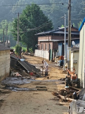 합천군 가회면 구평마을의 한 주민이 23일 집 앞 배구수의 이물질을 걷어내고 있다. 2025.7.23/뉴스1 한송학기자