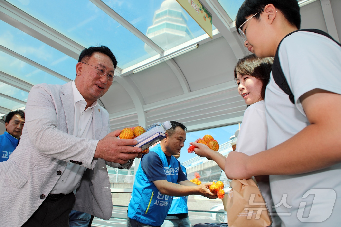강동훈 제주특별자치도관광협회 회장(왼쪽)과 강동훈 제주특별자치도렌터카조합 이사장이 25일 오전 제주국제공항 렌터카 주차장 비가림 통로에서 렌터카 교통사고 예방 캠페인의 일환으로 관광객들에게 감귤과 생수, 치약·칫솔 세트를 전달하고 있다. 2025.7.25/뉴스1 ⓒ News1 오미란 기자