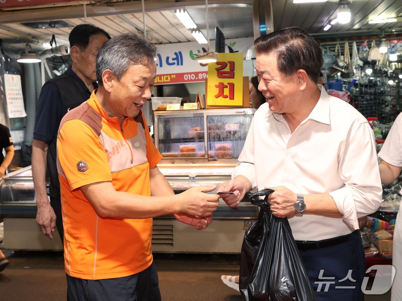 박승원 광명시장(오른쪽)이 지난해 광명새마을시장을 방문해 광명사랑화폐로 물품을 구매하고 있다.(광명시 제공)