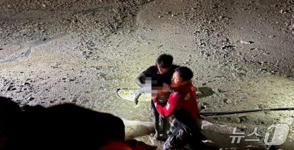 갯벌에 고립된 부자를 구조하는 해경. (목포해경 제공. 재판매 및 DB 금지)