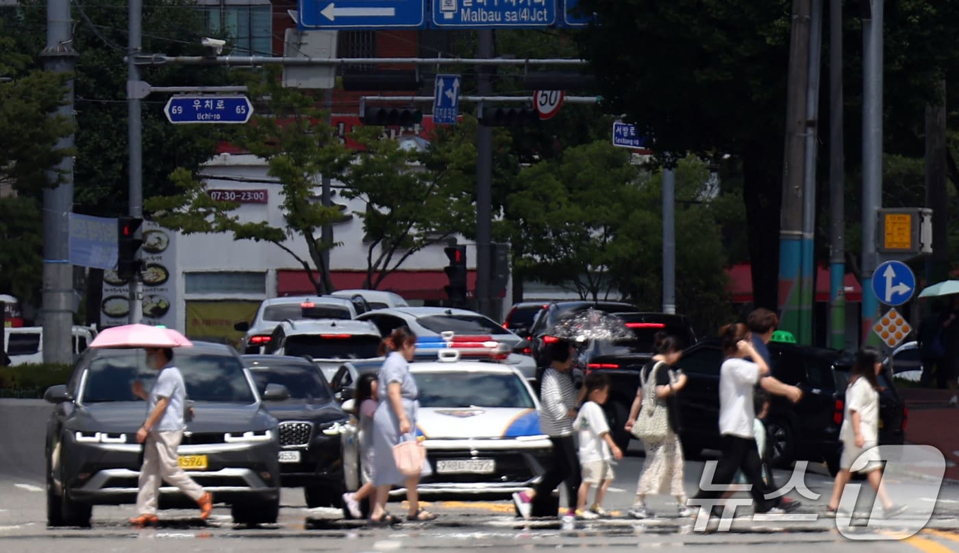 폭염경보가 발효된 28일 오후 시민들이 아지랑이가 피어오르고 있는 광주 북구청 사거리 신호등을 건너고 있다. 2025.7.28/뉴스1 ⓒ News1 박지현 기자