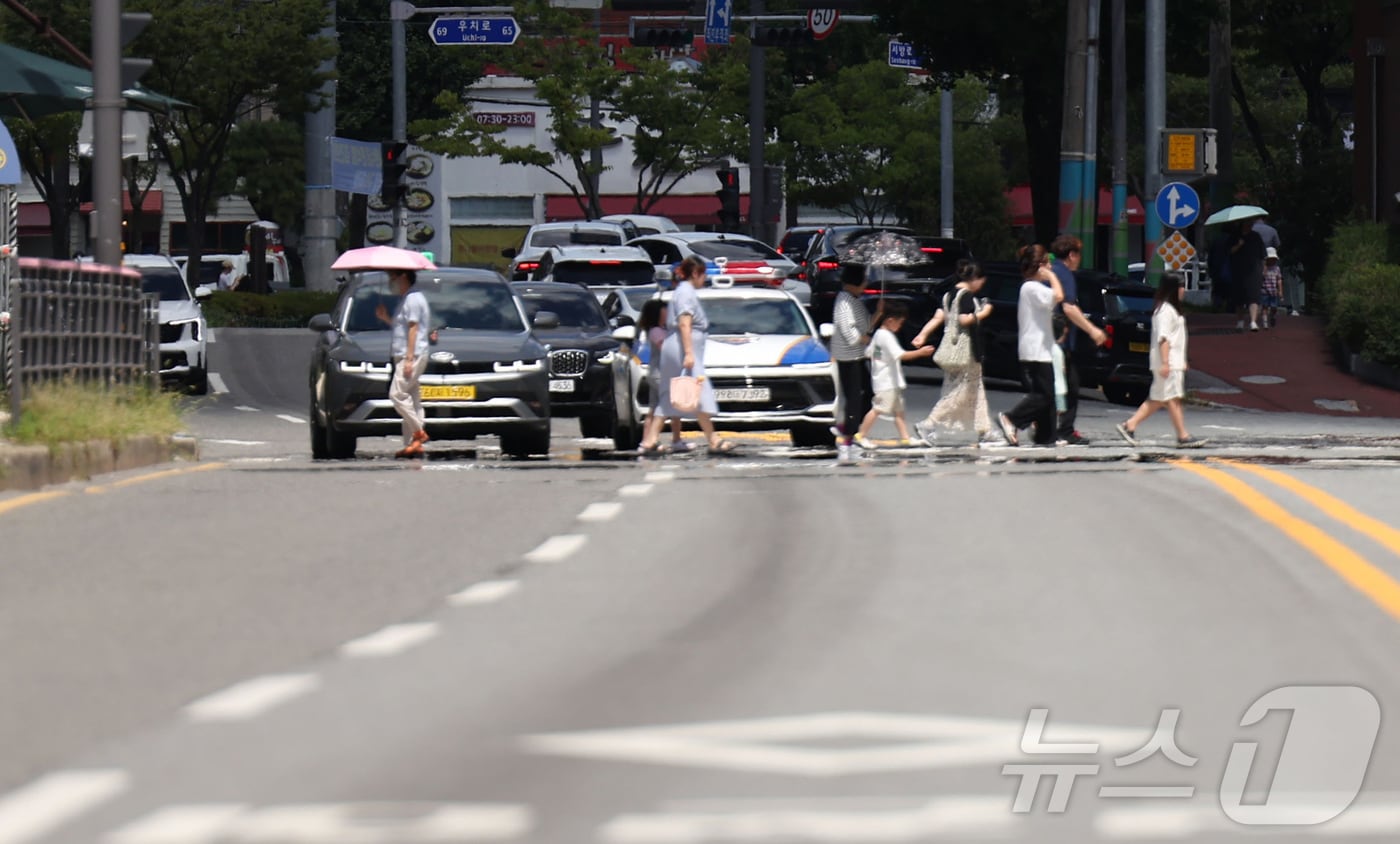 폭염경보가 발효된 28일 오후 시민들이 아지랑이가 피어오르고 있는 광주 북구청 사거리 신호등을 건너고 있다. 2025.7.28/뉴스1 ⓒ News1 박지현 기자
