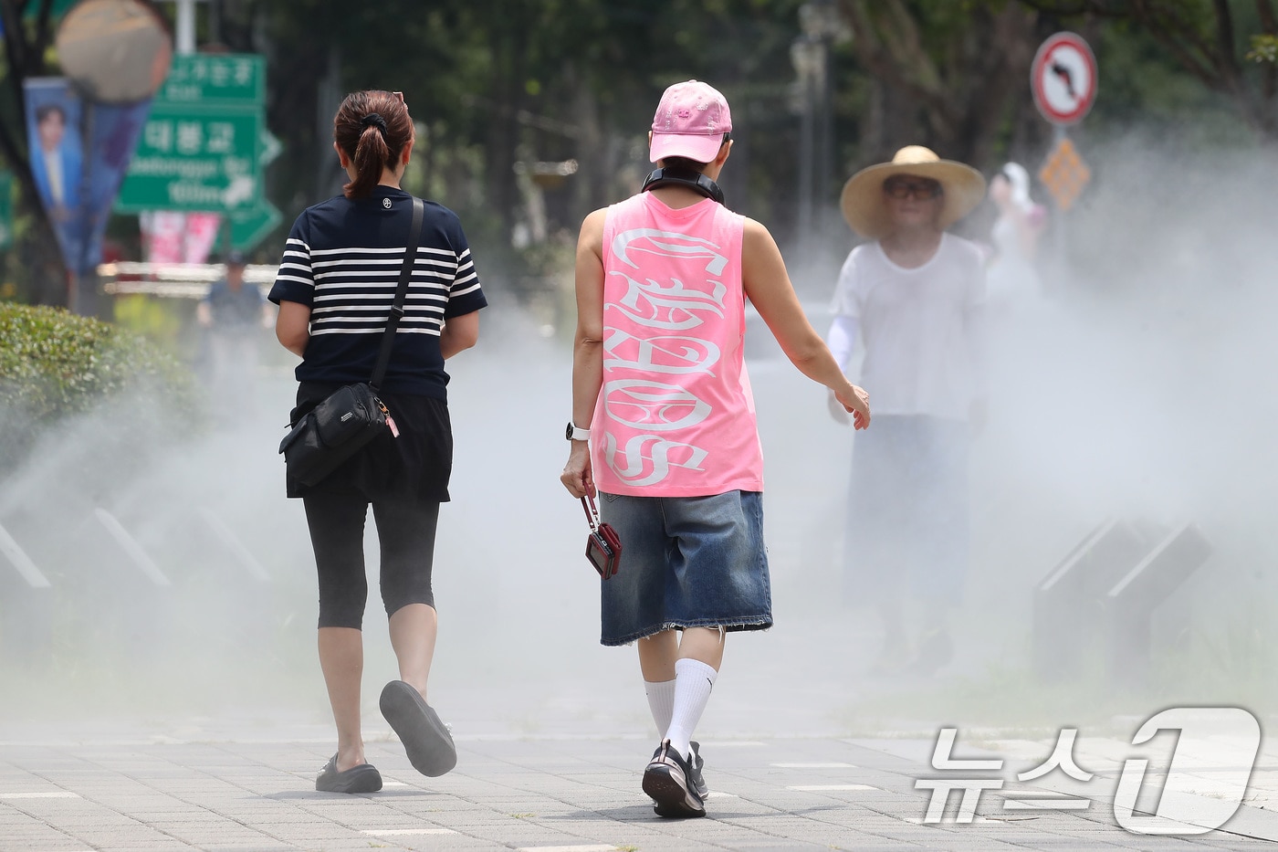 일주일째 폭염특보가 이어진 3일 대구 중구 김광석길 입구에 가동된 쿨링포그 사이로 시민들이 다양한 패션을 선보이며 걷고 있다. 2025.7.3/뉴스1 ⓒ News1 공정식 기자