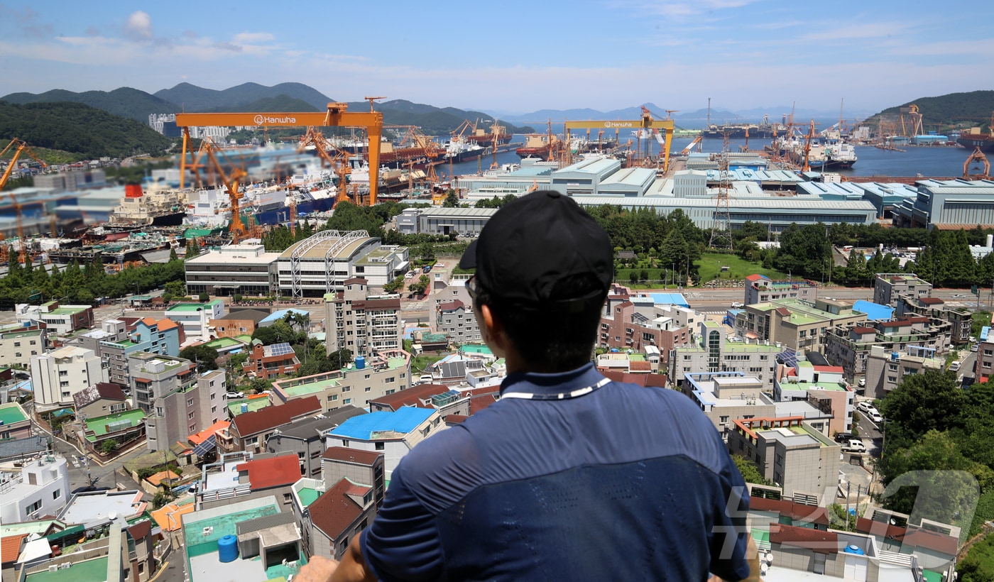 대미 수출 관세 인하와 조선업 투자를 골자로 한 한미 무역 협상이 타결된 31일 한 시민이 경남 거제시 아주동 주거단지 너머로 한화오션 거제사업장 대형 크레인을 바라보고 있다. 정부는 미국 도널드 트럼프 행정부와 무역 협상 합의에는 한국이 제안한 조선업 협력안인 &#39;마스가&#39;&#40;MASGA&#41; 프로젝트가 가장 크게 기여했다고 밝혔다. 2025.7.31/뉴스1 ⓒ News1 윤일지 기자