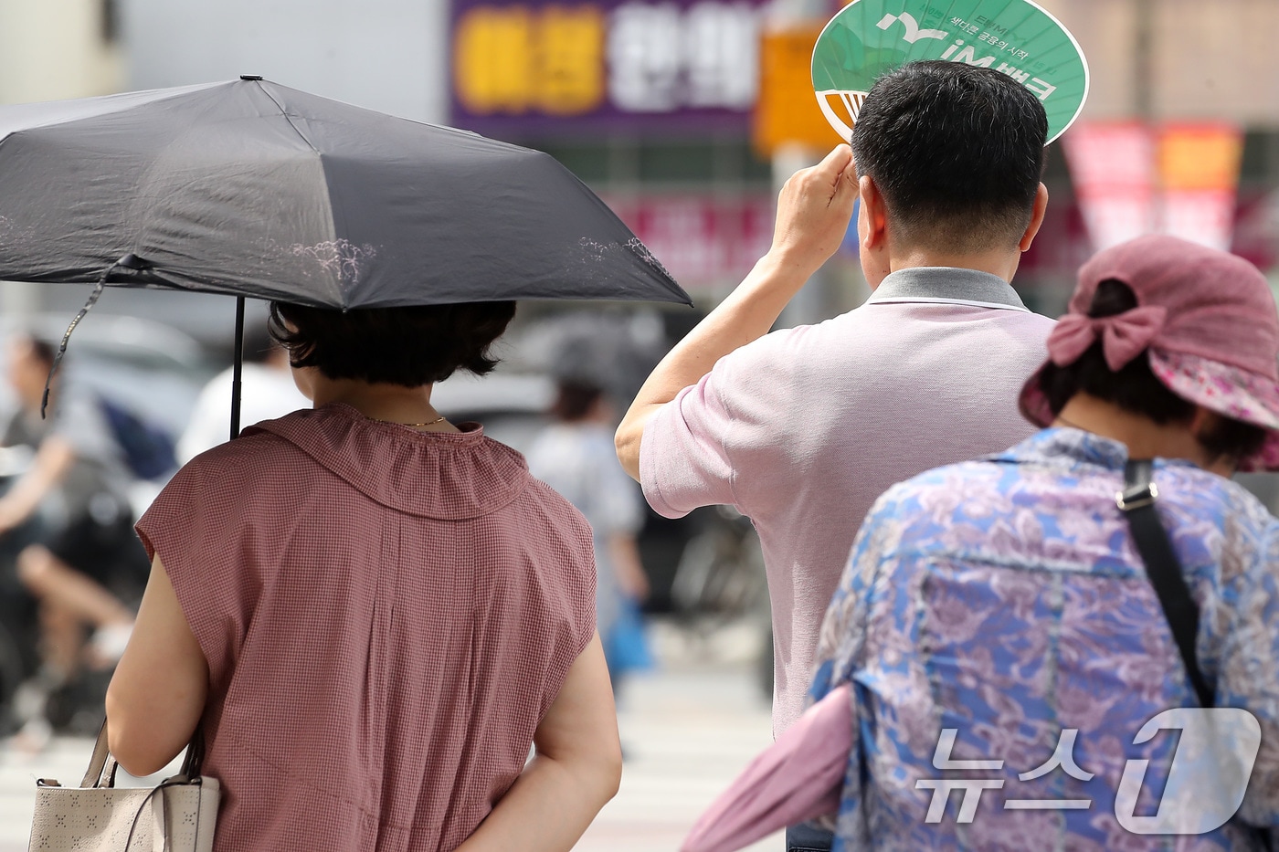 폭염이 일주일 넘게 이어진 4일 오후 대구 수성구 달구벌대로에서 시민들이 양산과 부채로 뙤약볕을 가리고 있다. 2025.7.4/뉴스1 ⓒ News1 공정식 기자