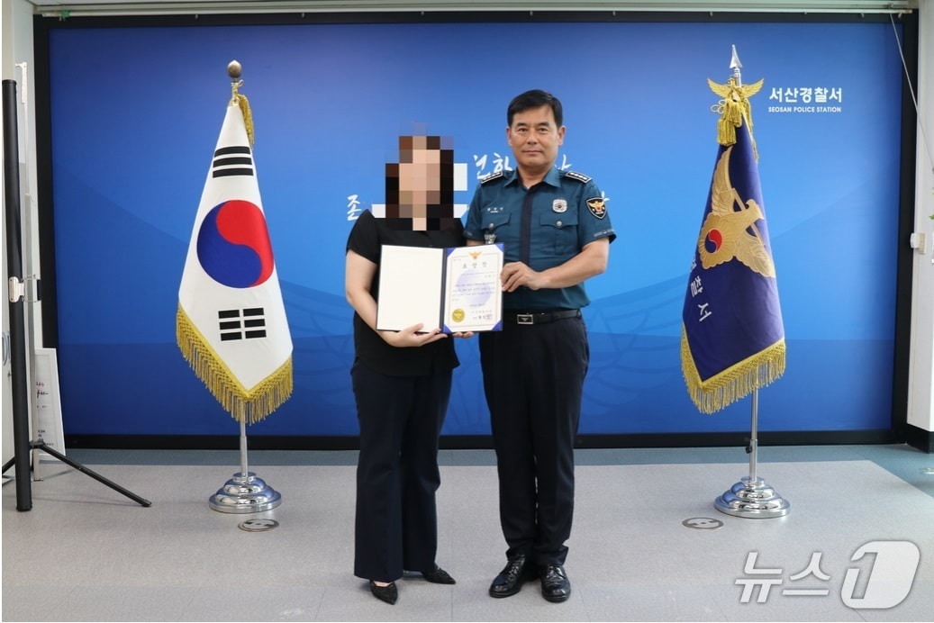 황정인 서산경찰서장이 학교 주변에서 흉기를 들고 배회한 남성을 신고해 검거에 도움을 준 여성에게 표창장을 수여하고 있다. (서산경찰서 제공, 재판매 및 DB금지) / 뉴스1 