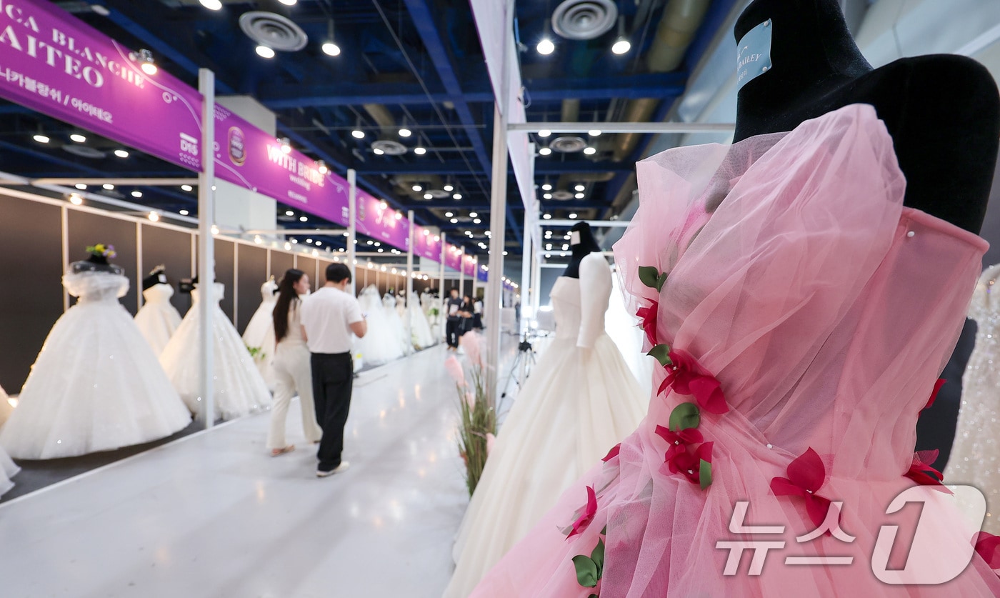 6일 서울 강남구 삼성동 코엑스에서 열린 2025 추계 웨덱스 웨딩 박람회에서 예비 부부들이 전시된 드레스를 살펴보고 있다. (사진은 기사 내용과 무관함) 뉴스1 ⓒ News1 김성진 기자