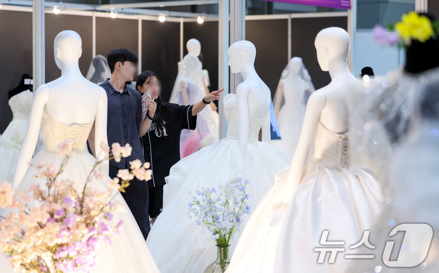서울 강남구 삼성동 코엑스에서 열린 2025 추계 웨덱스 웨딩 박람회에서 예비 부부들이 전시된 드레스를 살펴보고 있다. 2025.7.6 ⓒ 뉴스1 김성진 기자