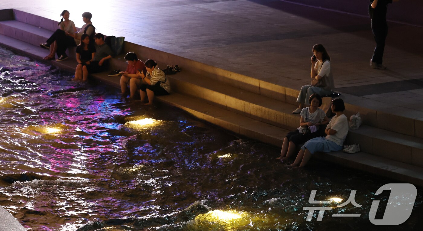 이른 폭염과 함께 열흘 넘게 열대야가 이어지고 있는 9일 저녁 서울 중구 청계천을 찾은 시민들이 더위를 식히고 있다. 2025.7.9/뉴스1 ⓒ News1 장수영 기자