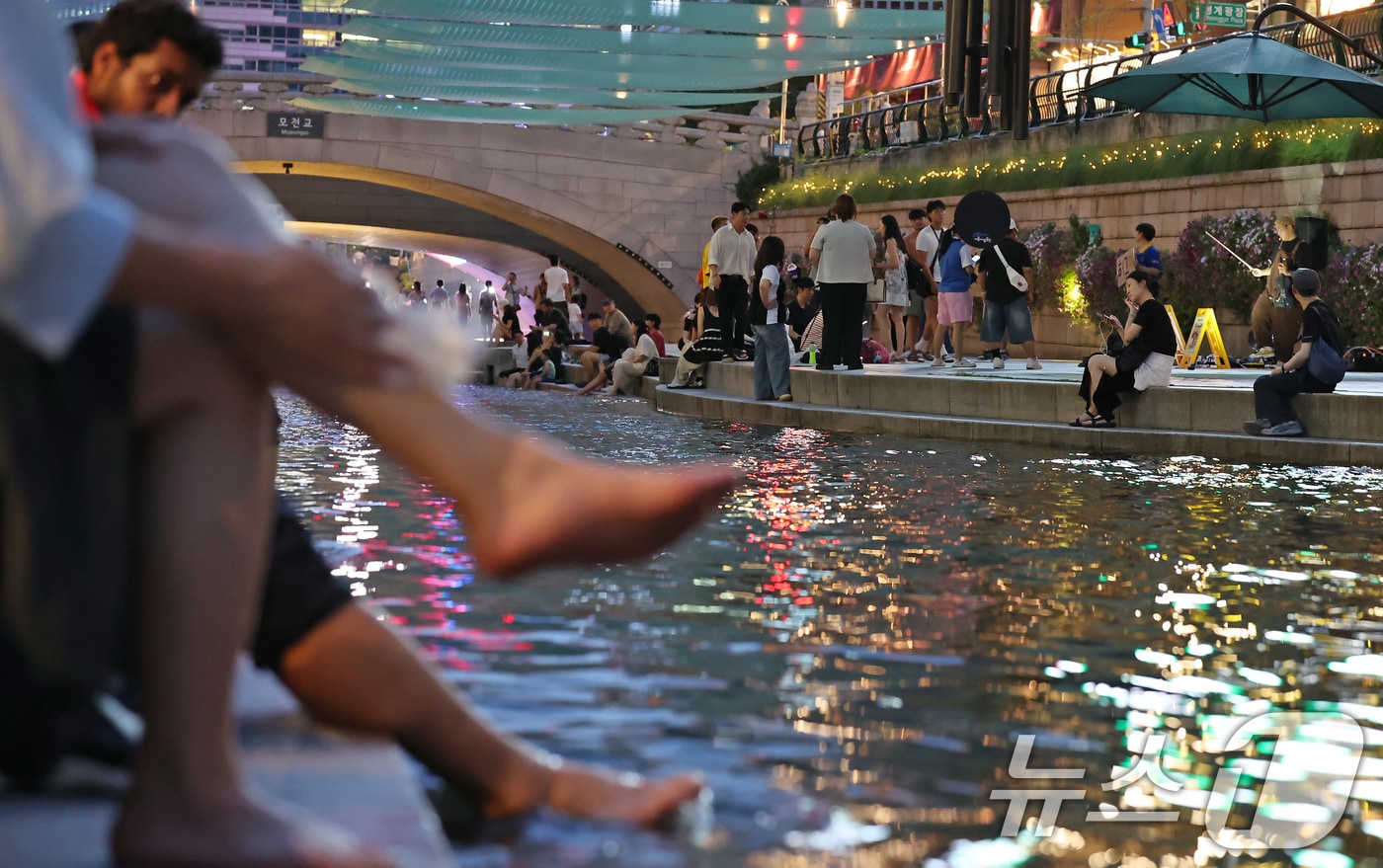 이른 폭염과 함께 열흘 넘게 열대야가 이어지고 있는 9일 저녁 서울 중구 청계천을 찾은 시민들이 더위를 식히고 있다. 2025.7.9/뉴스1 ⓒ News1 장수영 기자