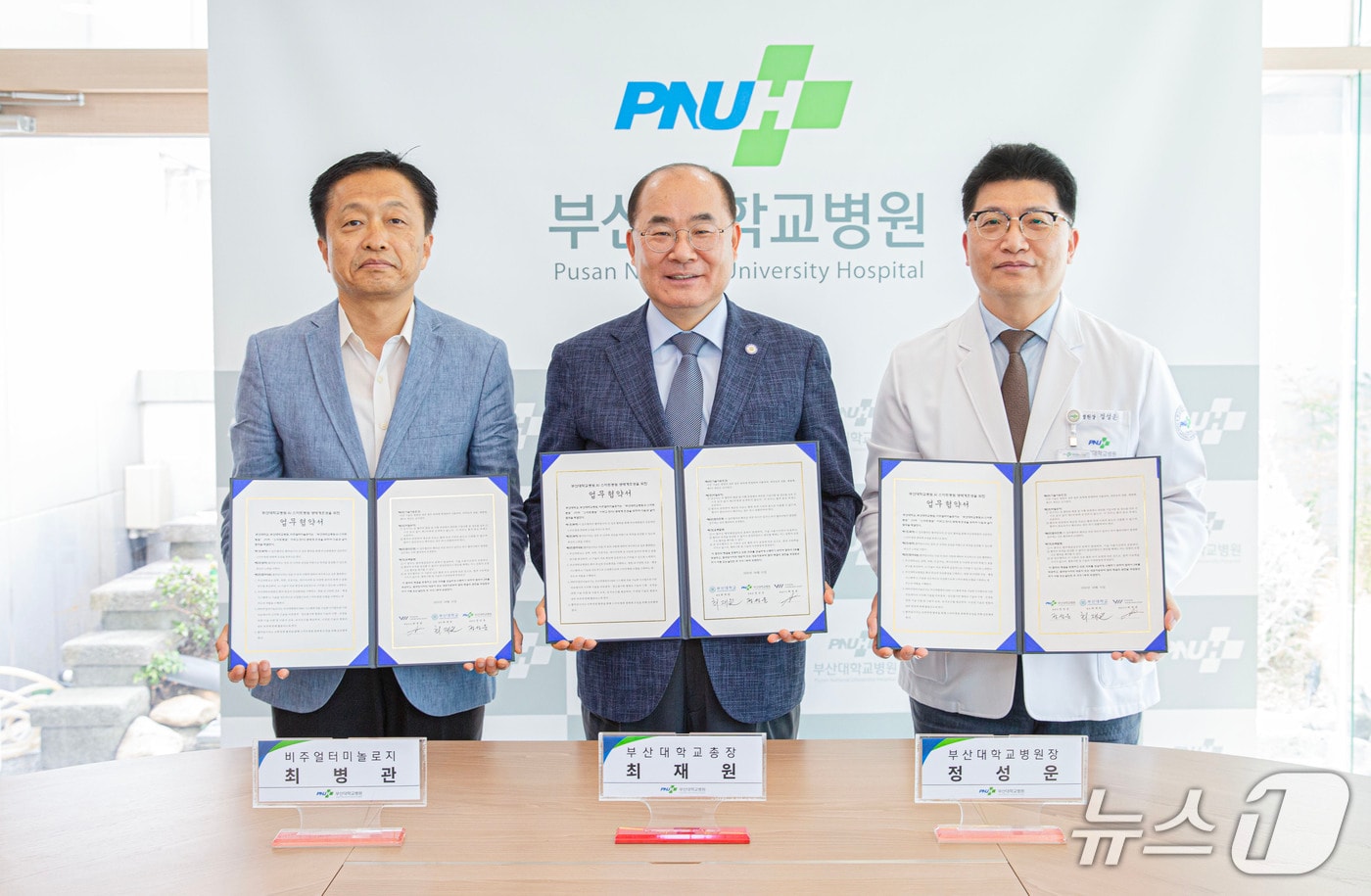 1일 부산 서구 부산대병원 J동 회의실에서 열린 ‘스마트병원 생태계 조성’을 위한 협약식에서 정성운 부산대병원장(오른쪽부터), 최재원 부산대 총장, 최병관 비주얼터미놀로지 대표가 협약서를 들어 보이고 있다. (부산대병원 제공. 재판매 및 DB 금지)