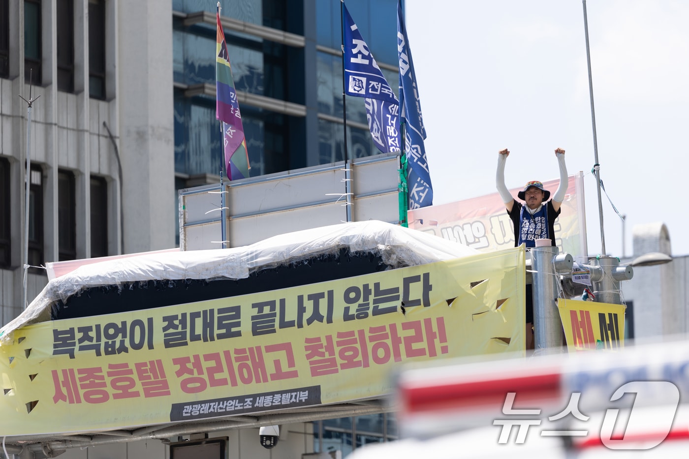 정리해고 철회를 촉구하며 고공 농성을 이어가고 있는 고진수 관광레저산업노조 세종호텔 지부장이 10일 오후 서울 중구 세종호텔 앞 구조물 고공농성장에서 특별 연대 행사 참가자들의 응원에 팔을 들어 인사하고 있다. (사진은 기사 내용과 무관함) 2025.8.10 ⓒ 뉴스1 이승배 기자
