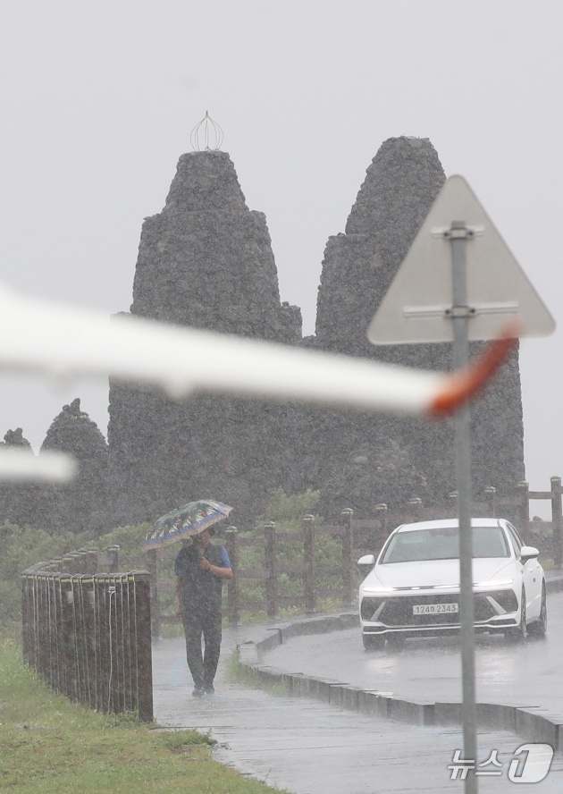  제주시 용담해안도로에서 우산을 쓴 행인이 발걸음을 옮기고 있다. 2025.8.11/뉴스1 ⓒ News1 오현지 기자