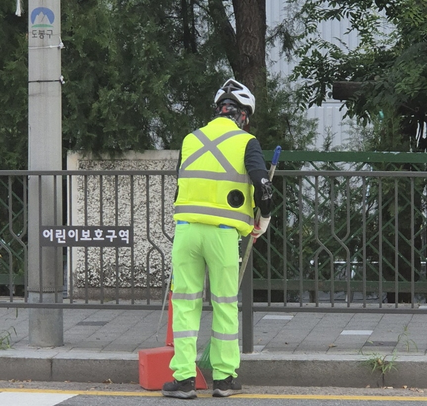 도봉구 야외 청소 현업근로자가 선풍기 조끼를 입고 도봉구 지역 내 한 도로를 청소하고 있다.(도봉구 제공)