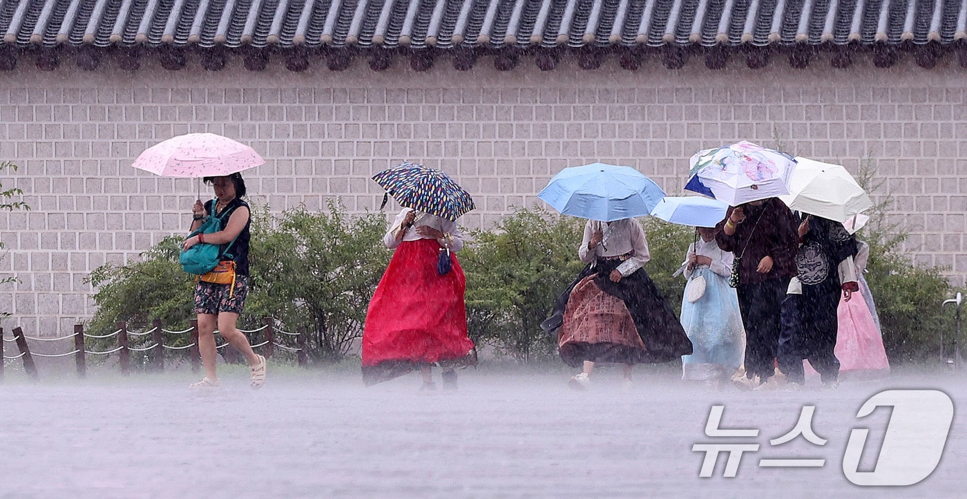 호우특보가 발효된 13일 서울 종로구 국립고궁박물관 인근에서 외국인 관광객들이 우산을 쓴 채 발걸음을 옮기고 있다. 2025.8.13/뉴스1 ⓒ News1 박지혜 기자